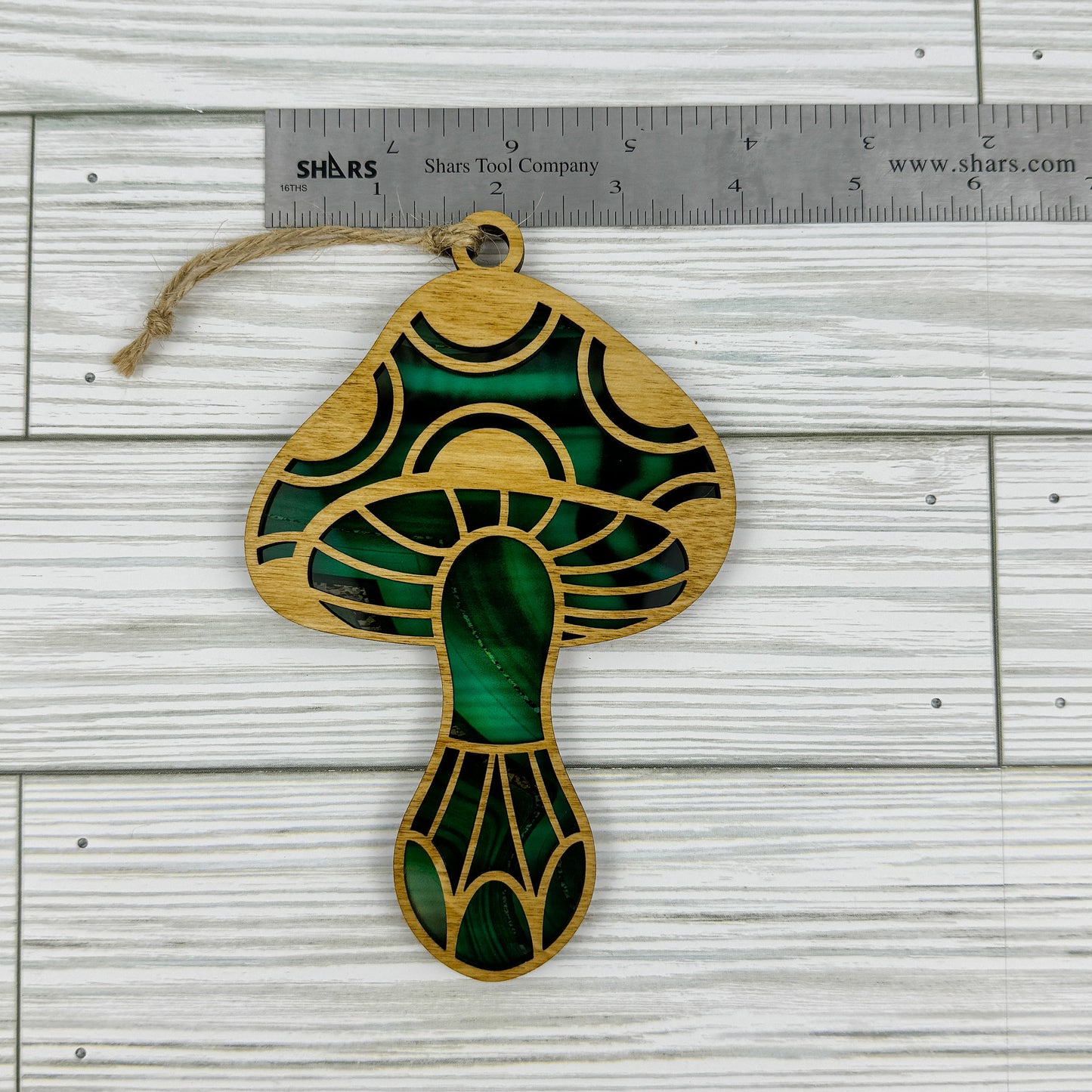 Mushroom suncatcher made from wood and acrylic lying flat with a ruler showing the approximate width.