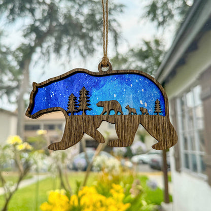 Bear suncatcher made from wood and acrylic hanging in window shown in the dark stain option.