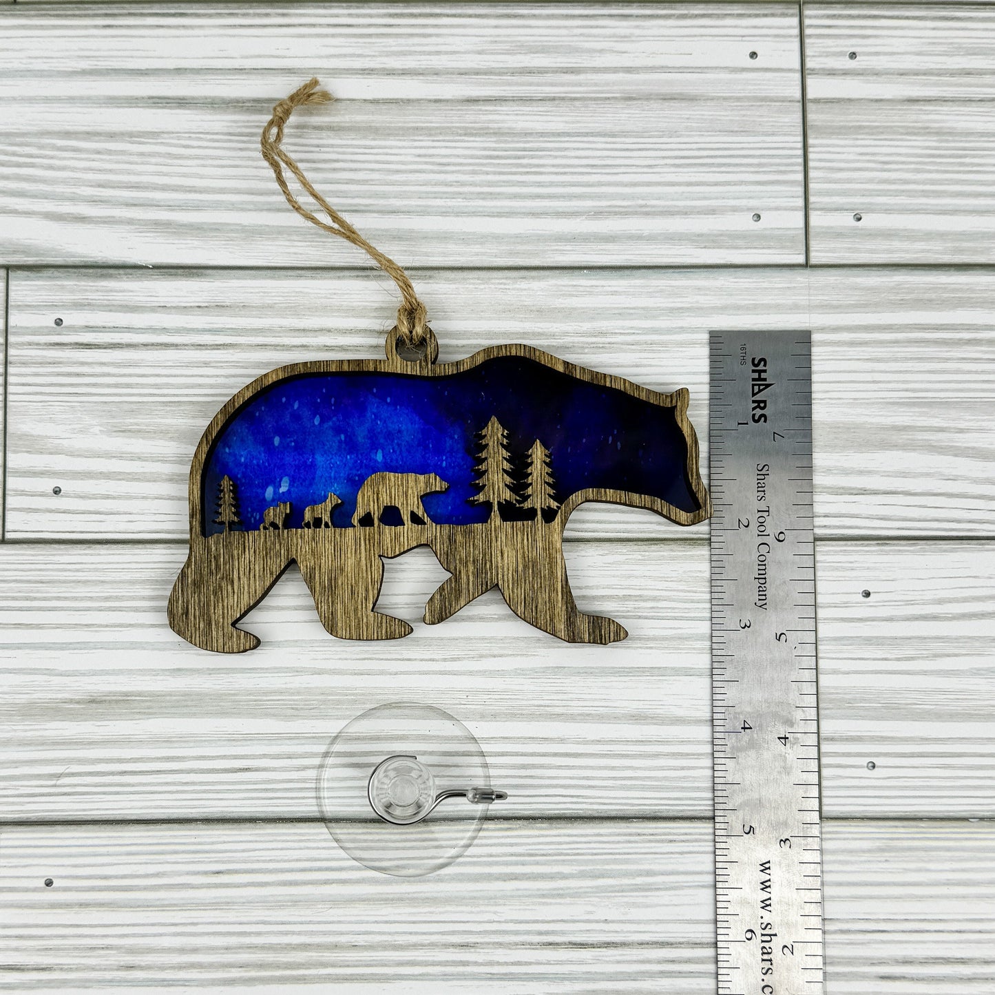 Bear suncatcher made from wood and acrylic lying flat with a ruler showing the approximate height.