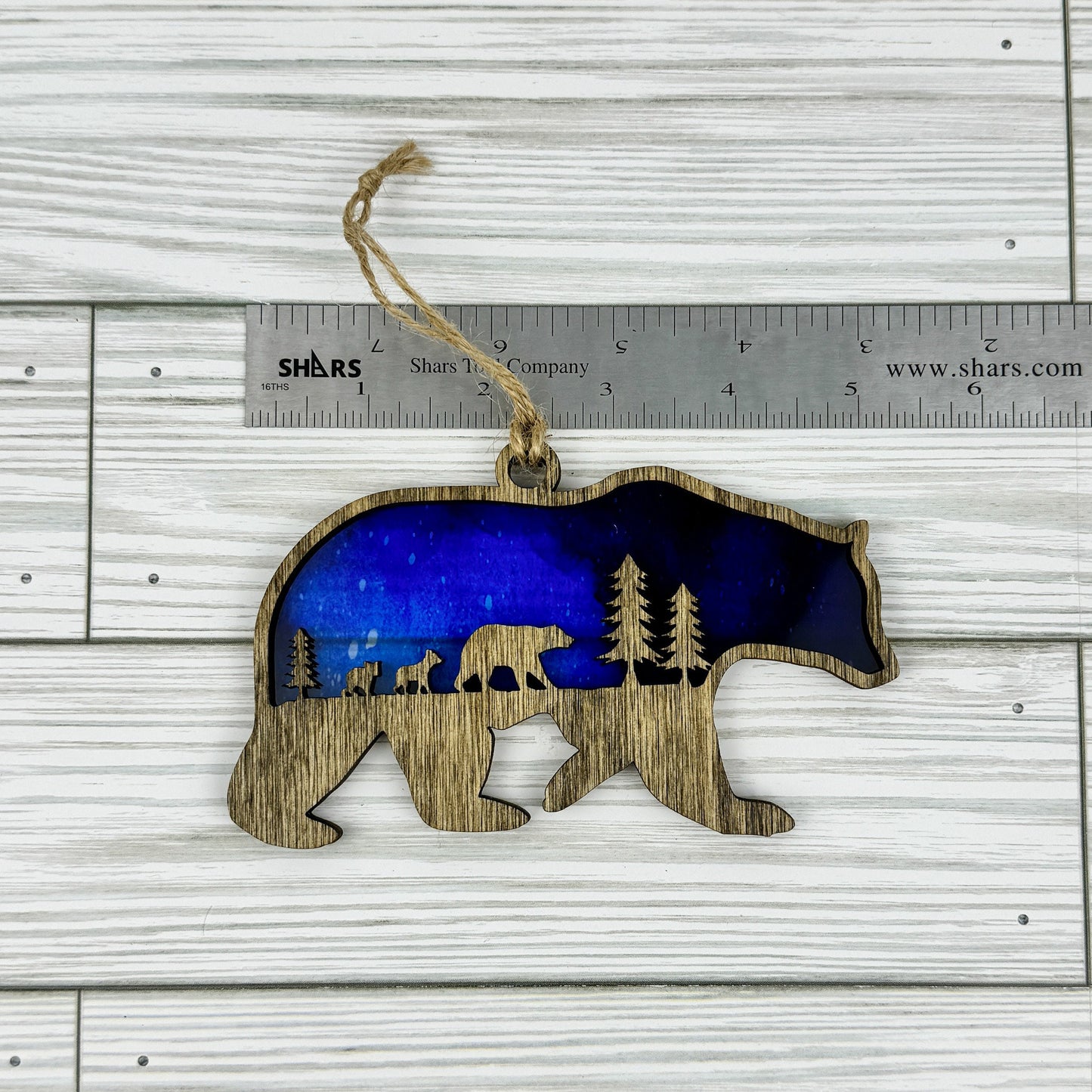 Bear suncatcher made from wood and acrylic lying flat with a ruler showing the approximate width.