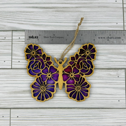 Floral butterfly suncatcher made from wood and acrylic lying flat with a ruler showing the approximate width