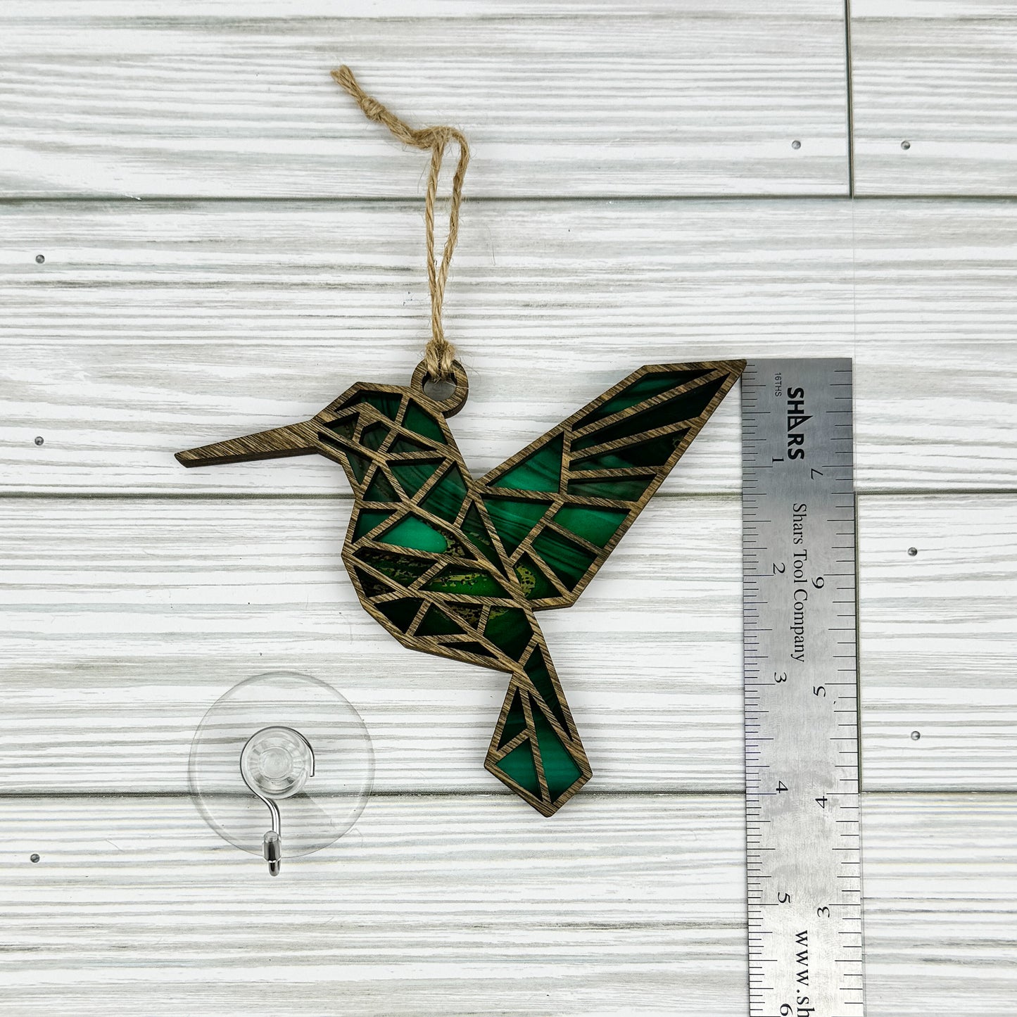 Hummingbird suncatcher made from wood and acrylic lying flat with a ruler showing the approximate height.