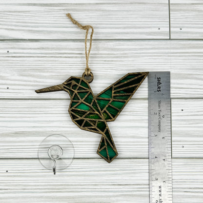 Hummingbird suncatcher made from wood and acrylic lying flat with a ruler showing the approximate height.