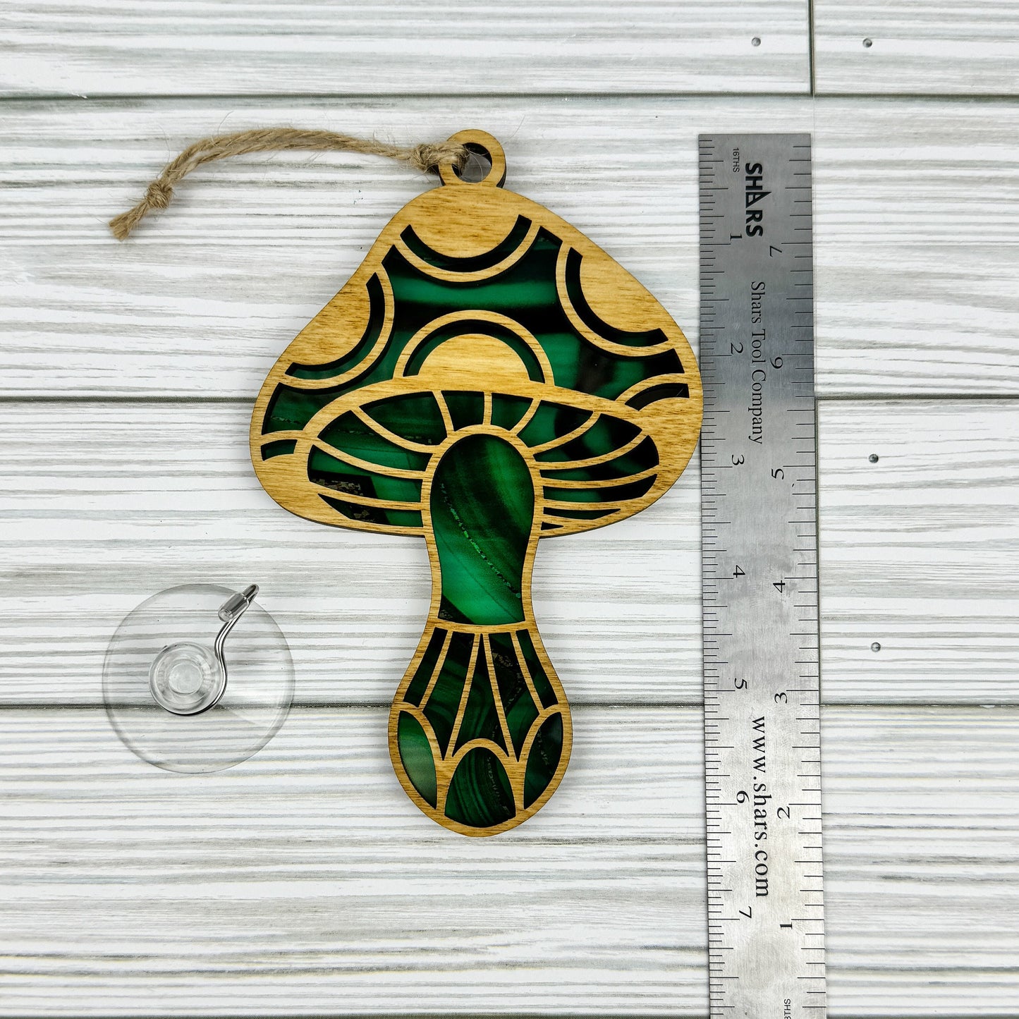 Mushroom suncatcher made from wood and acrylic lying flat with a ruler showing the approximate height.