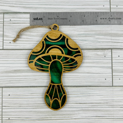 Mushroom suncatcher made from wood and acrylic lying flat with a ruler showing the approximate width.