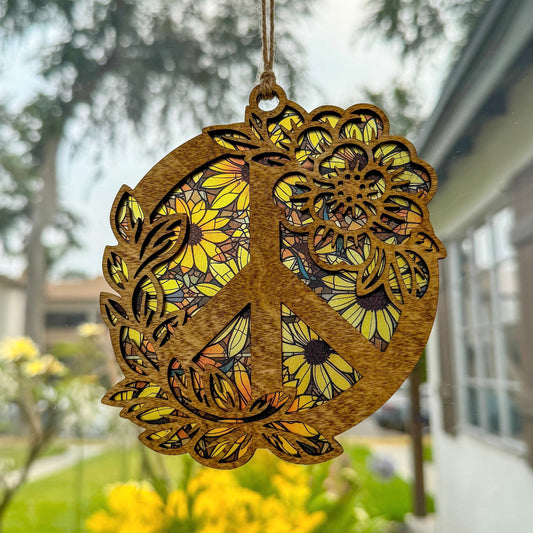 Floral peace sign suncatcher made from wood and acrylic hanging in window shown in the light stain option.