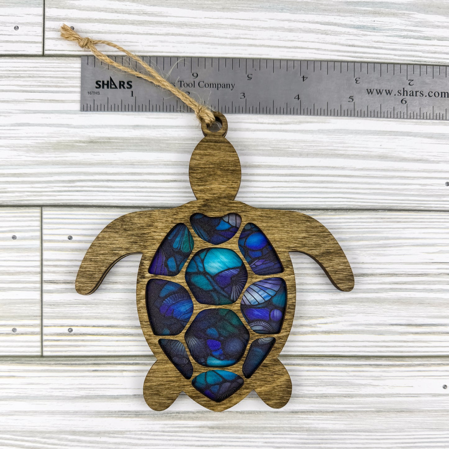 Sea Turtle suncatcher made from wood and acrylic lying flat with a ruler showing the approximate height.