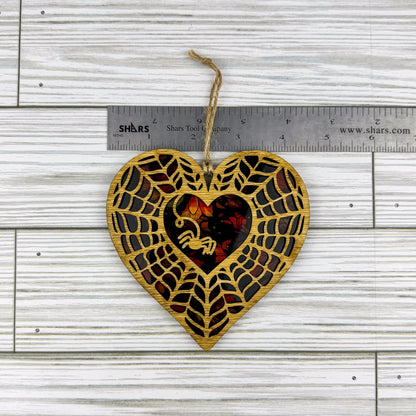 Spiderweb heart shaped suncatcher made from wood and acrylic lying flat with a ruler showing the approximate width.