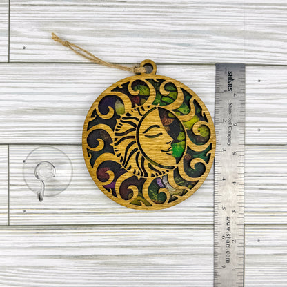 Sun suncatcher made from wood and acrylic lying flat with a ruler showing the approximate height.